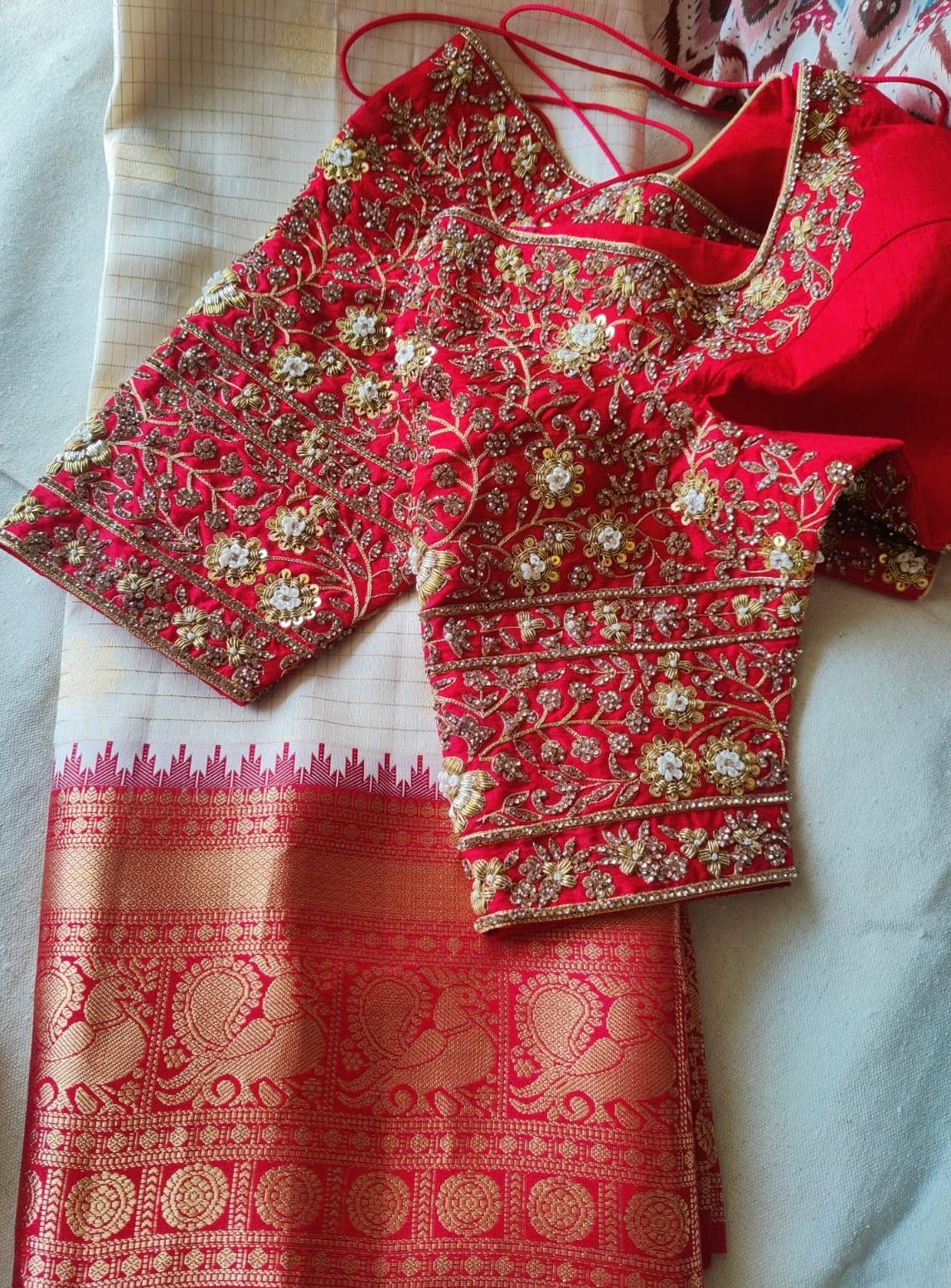 Luxury red bridal blouse featuring heavy maggam and zardozi embroidery, rich handwork, and elegant designer sleeves perfect for weddings and grand occasions.