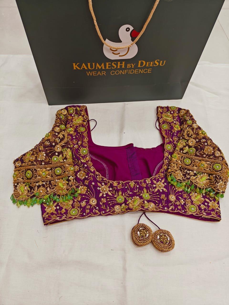 Premium purple bridal blouse with heavy maggam and zardozi embroidery, green stone detailing, and elegant handcrafted finish for weddings and grand occasions.