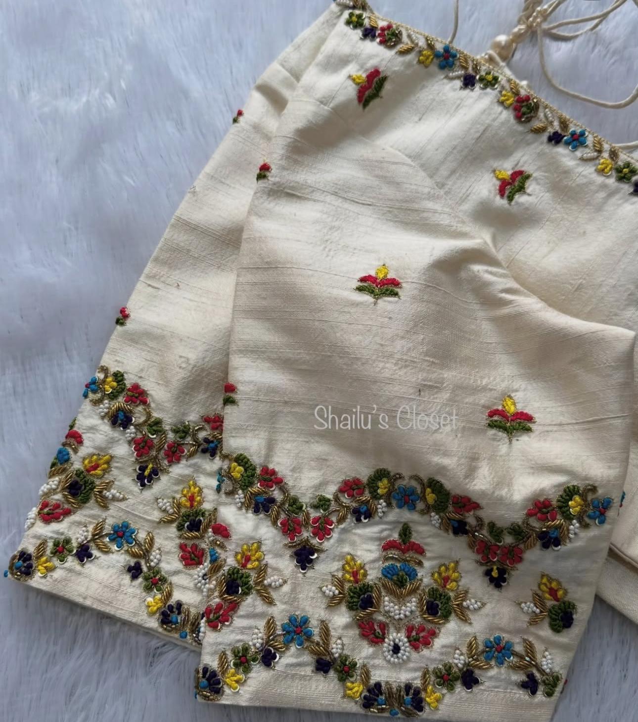 Elegant cream blouse featuring heavy embroidery around the neckline, ideal for wedding and partywear sarees.