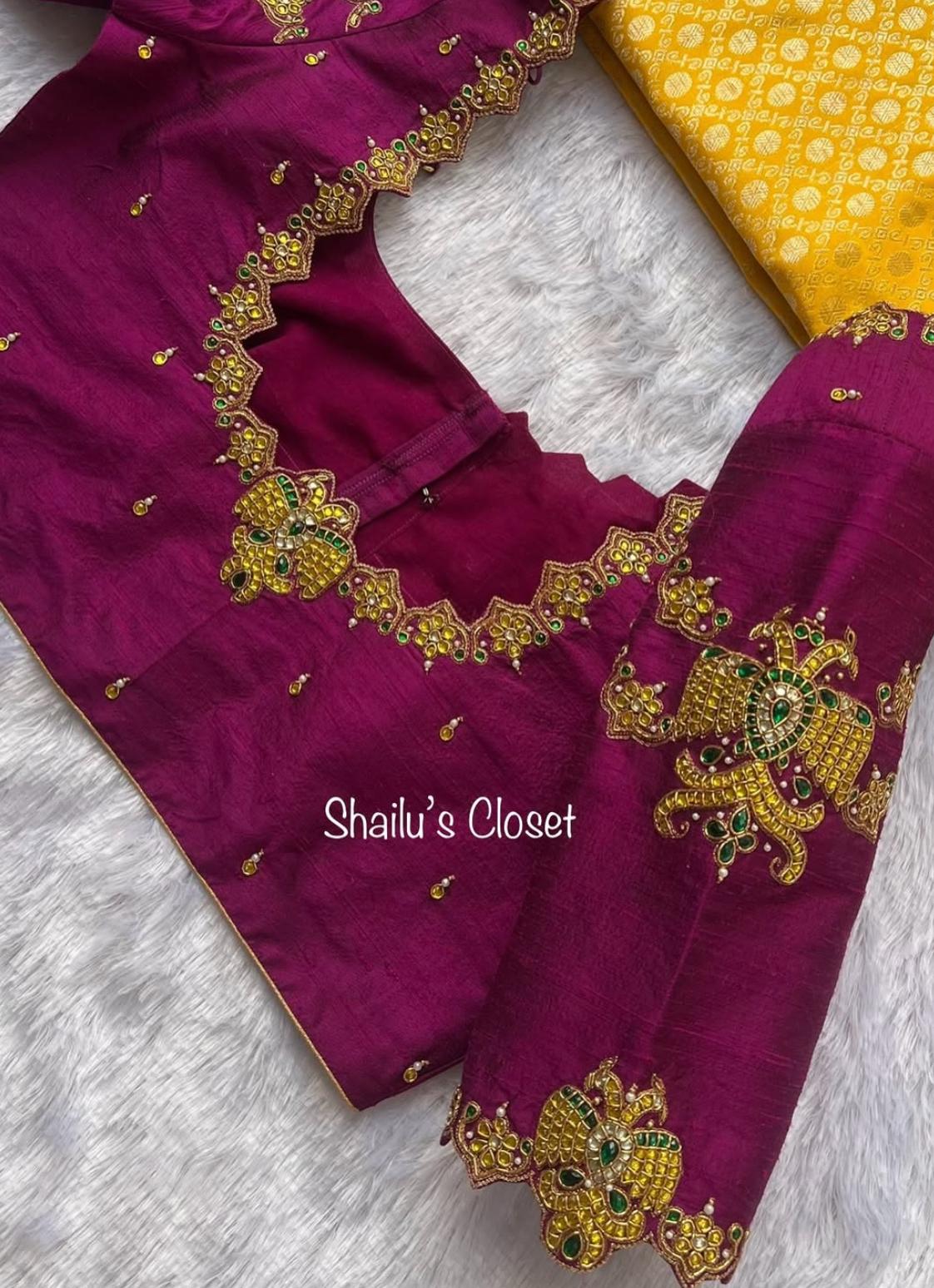 Rich magenta premium bridal blouse featuring heavy floral maggam work embroidery with intricate stone and thread detailing, perfect for weddings and grand festive occasions.