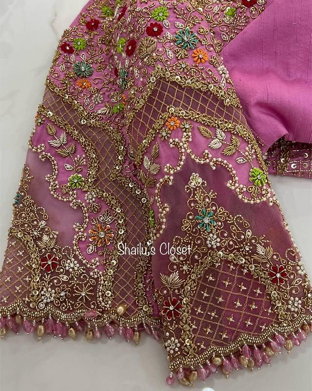 Rich pink bridal blouse adorned with dense maggam embroidery and intricate detailing, ideal for grand wedding occasions.