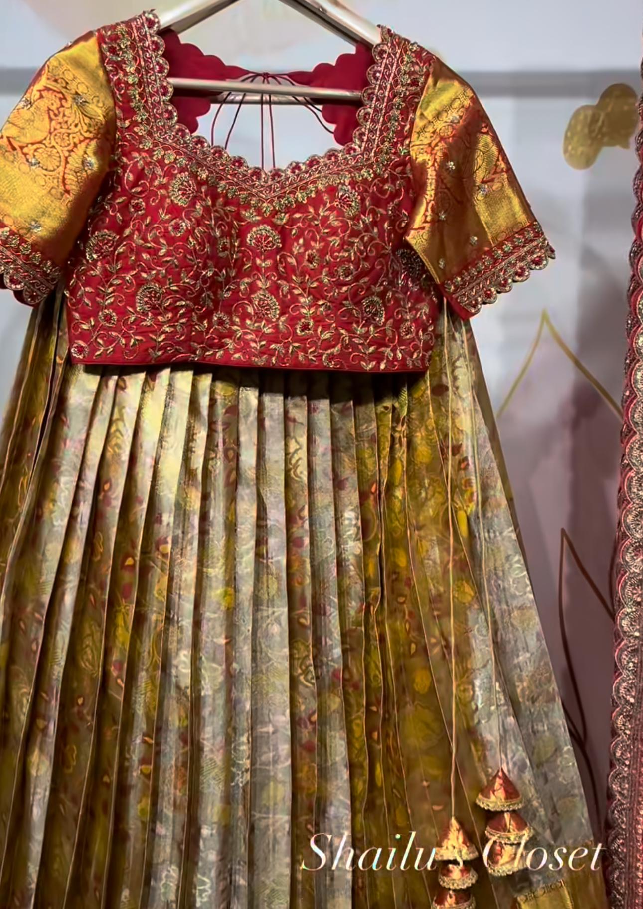 Elegant red designer lehenga set with heavily embroidered blouse, displayed on mannequin, perfect for wedding and reception ceremonies.