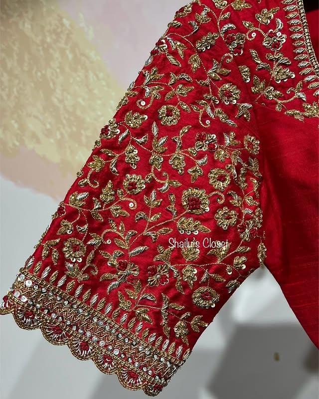 Red blouse sleeve featuring intricate floral maggam embroidery, ideal for bridal and festive outfits.